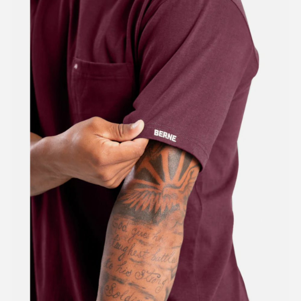 Person wearing a maroon shirt with 'Berne' branding, showing tattooed arm.