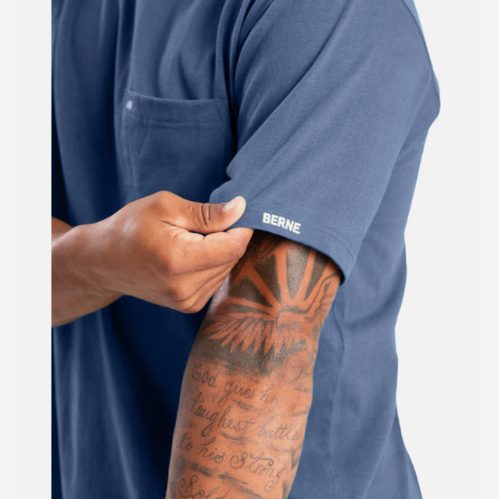 Person wearing a blue shirt with 'Berne' branding, showing a tattooed arm.
