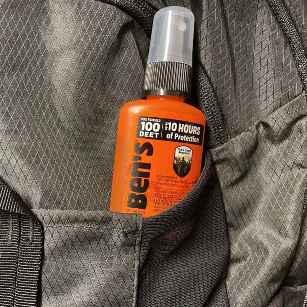 Ben's insect repellent spray bottle in a gray backpack