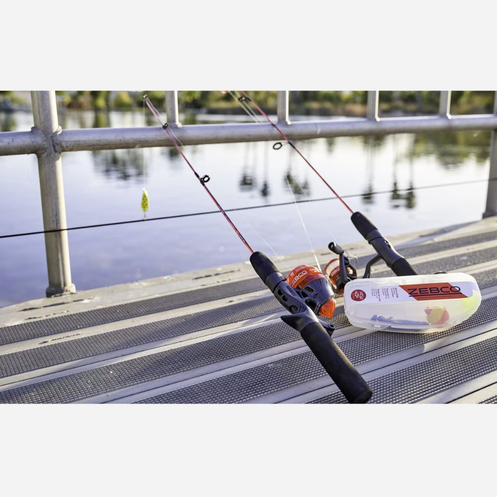 Fishing rod and reel on a dock with water and trees in the background