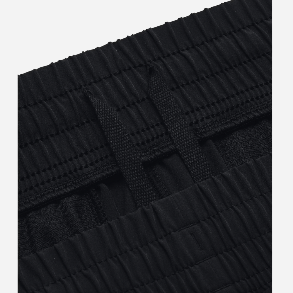 Close-up of a black textured belt with a buckle on a light gray background