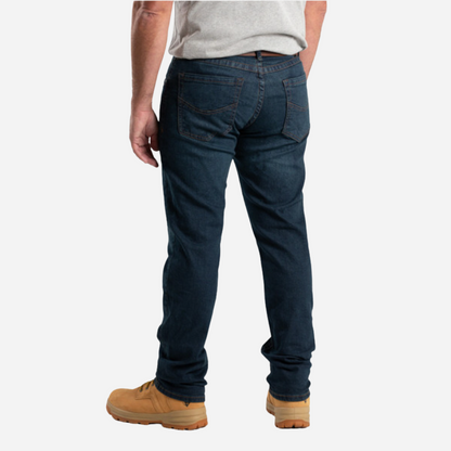 Person wearing dark blue jeans and tan boots on a white background