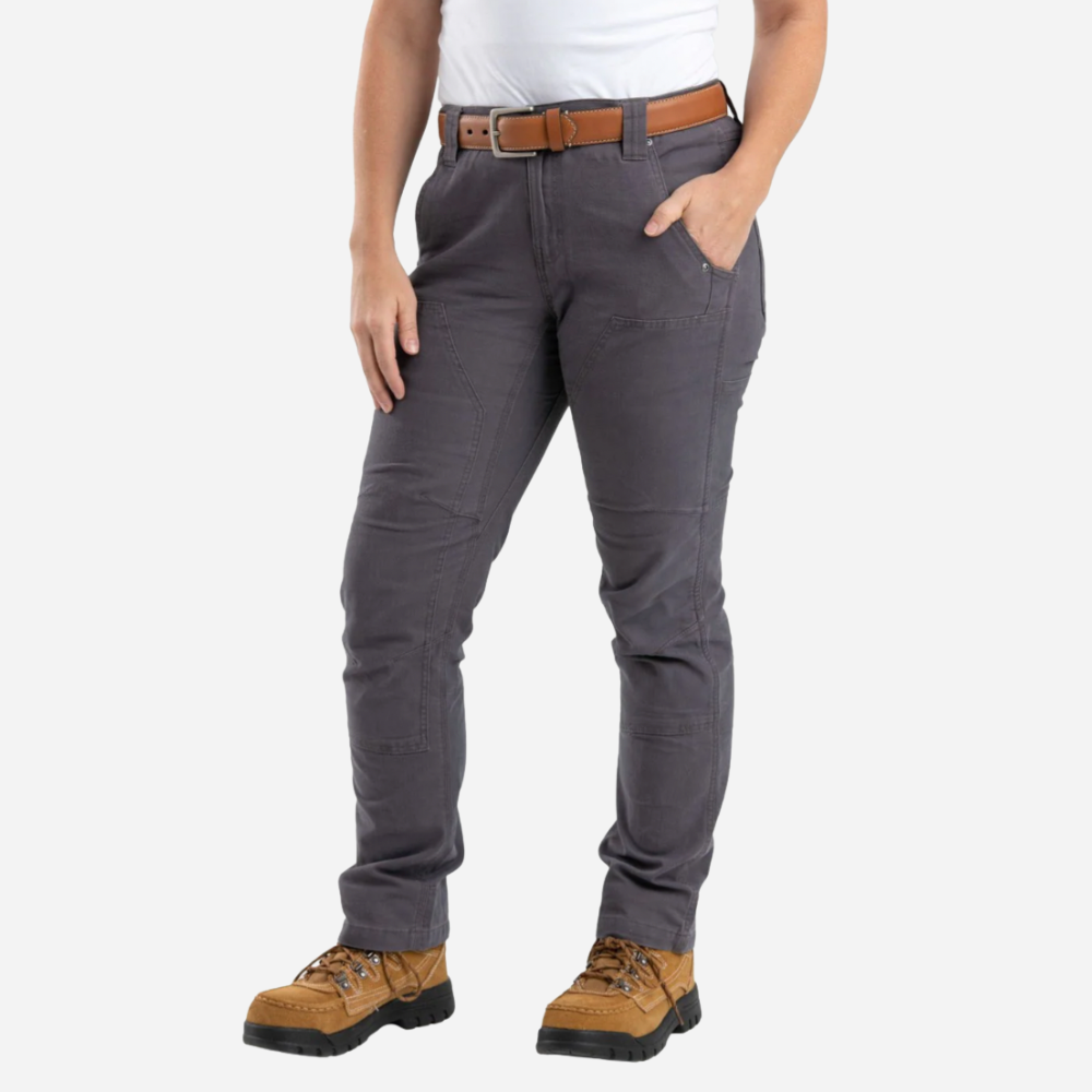 Person wearing gray pants with a brown belt and tan boots on a white background