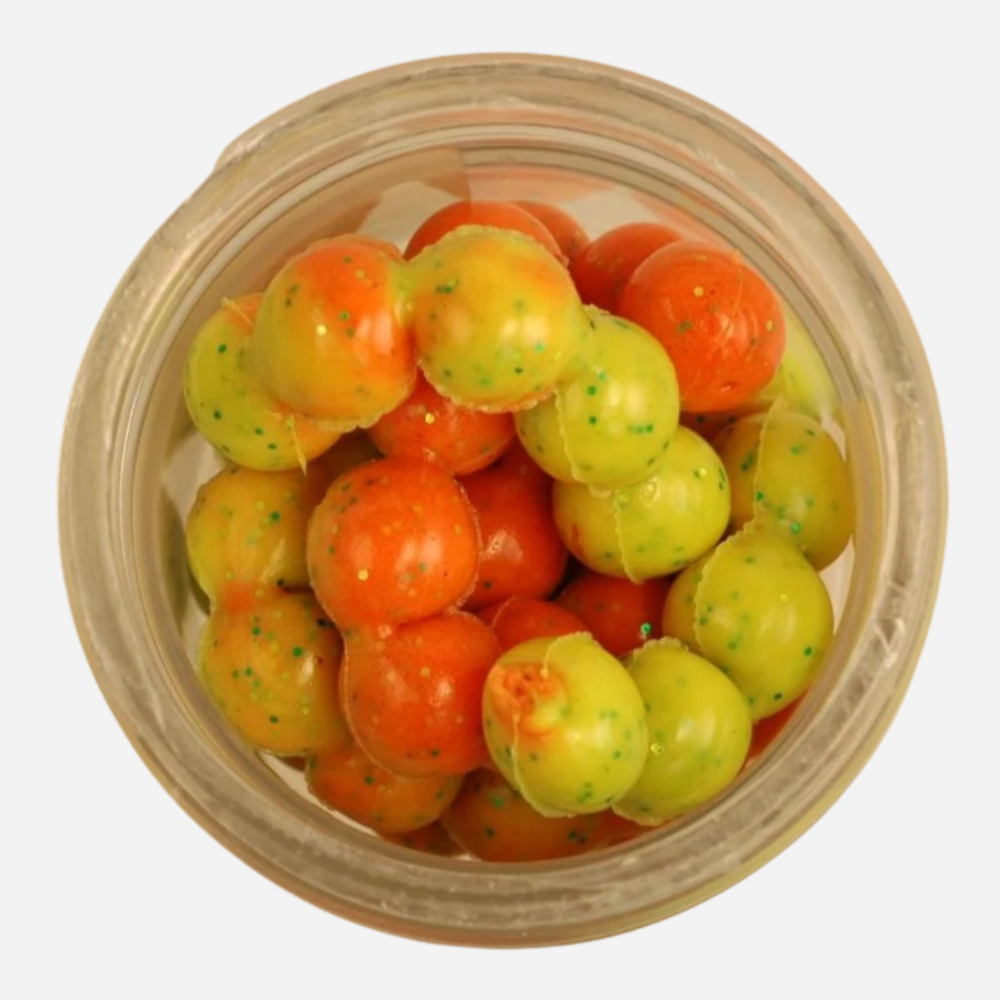 Jar filled with orange and green gumballs on a white background