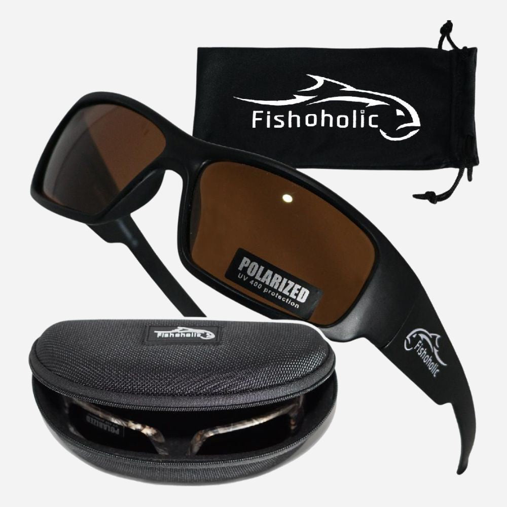 Black polarized sunglasses with brown lenses, shown with a black drawstring pouch and a black hard case. The Fishoholic brand name and fish logo are visible on the glasses, pouch, and case.
