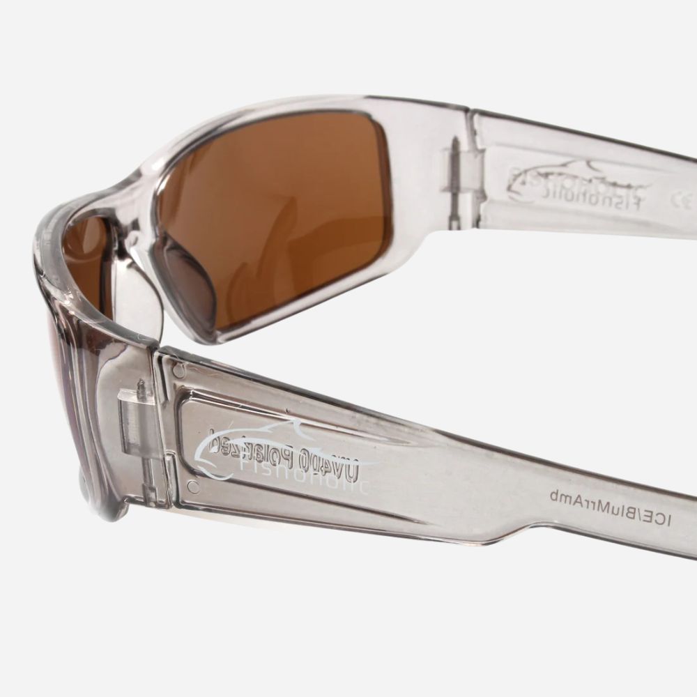 Close-up of a pair of sunglasses with a translucent clear frame and brown tinted lenses, showing the inner temple branding.