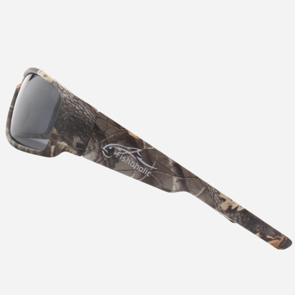Fishholic sunglasses with a brown and beige woodland camouflage pattern on the frames and arms, featuring dark tinted lenses and a white fish logo with the brand name on the temple.