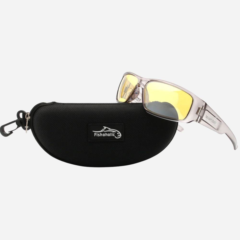 A pair of sunglasses with a translucent white frame and yellow mirrored lenses, displayed next to a black zippered hard case featuring the Fishaholic brand logo, set against a light gray background.