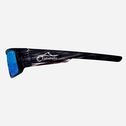 A pair of black sunglasses with a textured, glossy finish and a blue glittery lens, featuring the 'Fishoholic' brand logo printed in white on the temple arm, set against a plain light gray background.