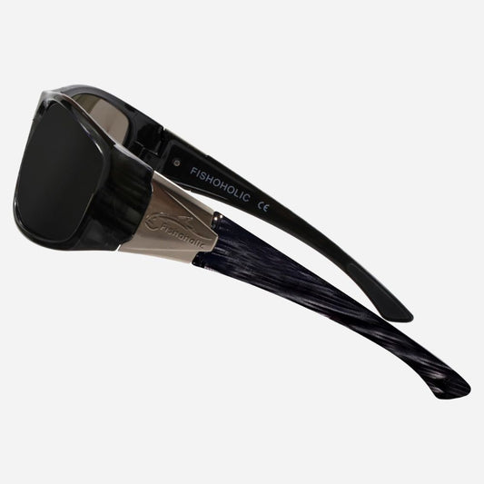 FISHOHOLIC sunglasses with a glossy black frame, dark lenses, and a dark marbled acetate temple arm, shown on a light gray background.