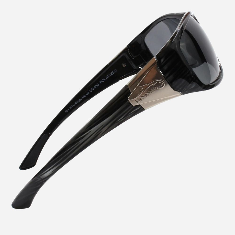 Black sunglasses with a glossy tortoiseshell pattern on the arms, a metallic gold bridge, and dark tinted lenses, shown on a light gray background.