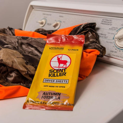 Scent Killer dryer sheets package on a washing machine with orange and camouflage clothing.