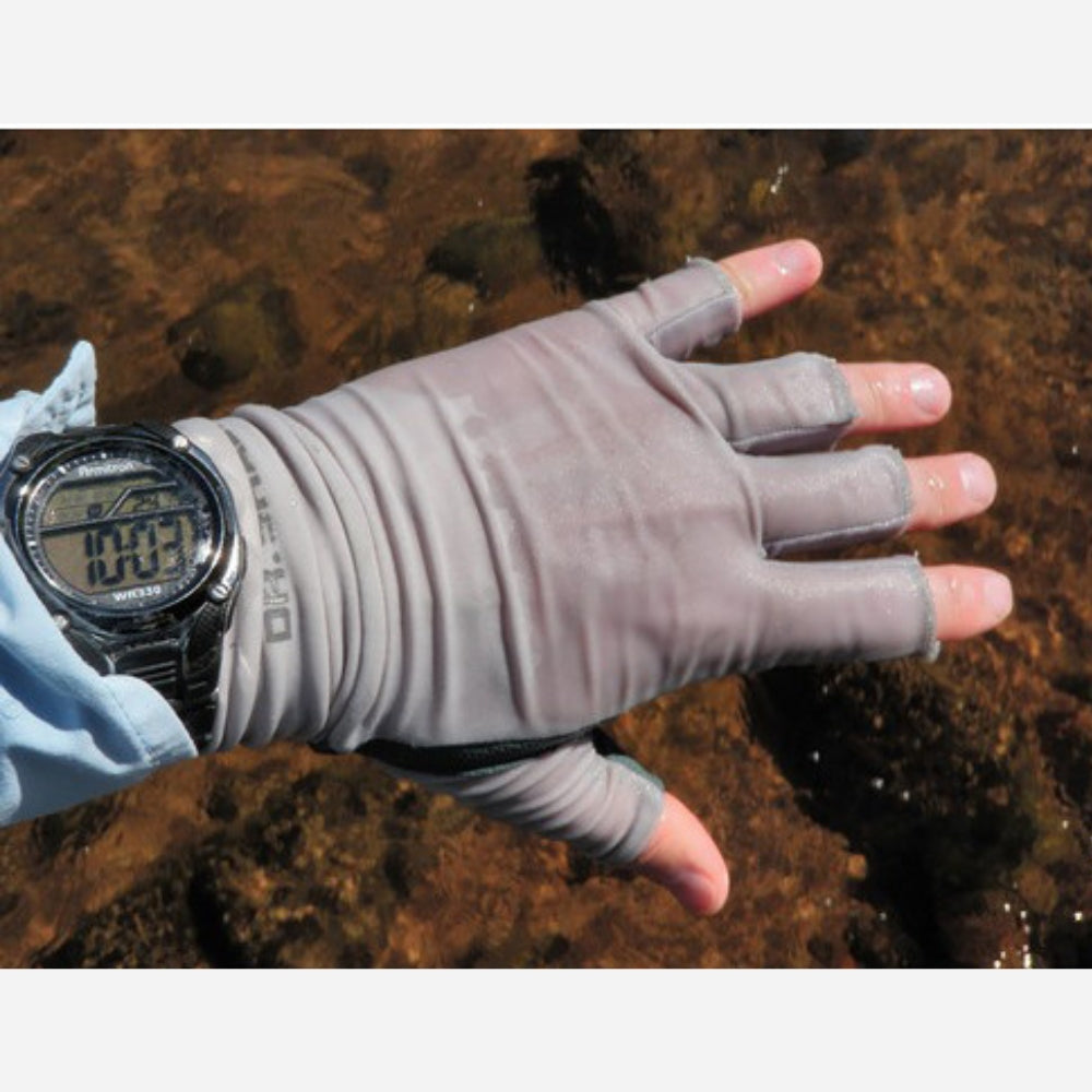 Hand wearing a gray fishing glove with a digital watch, over a natural background.
