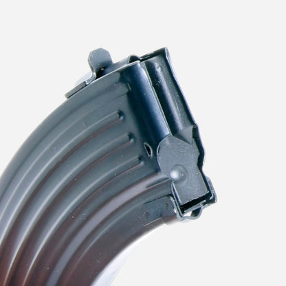 Close-up of a black curved plastic magazine or grip component with ribbed texture and a latch detail, shown against a plain light gray background.