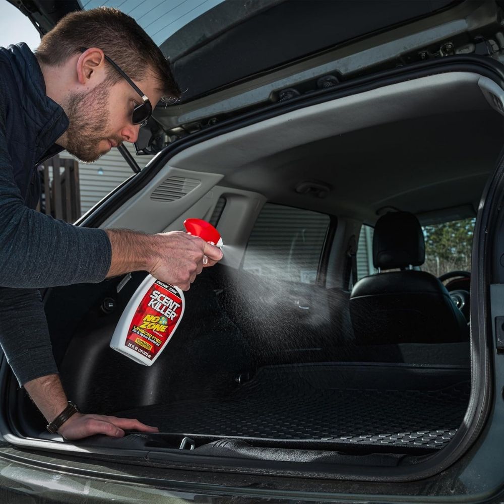 Person spraying Scent Killer No Zone deodorizer inside the cargo area of a vehicle