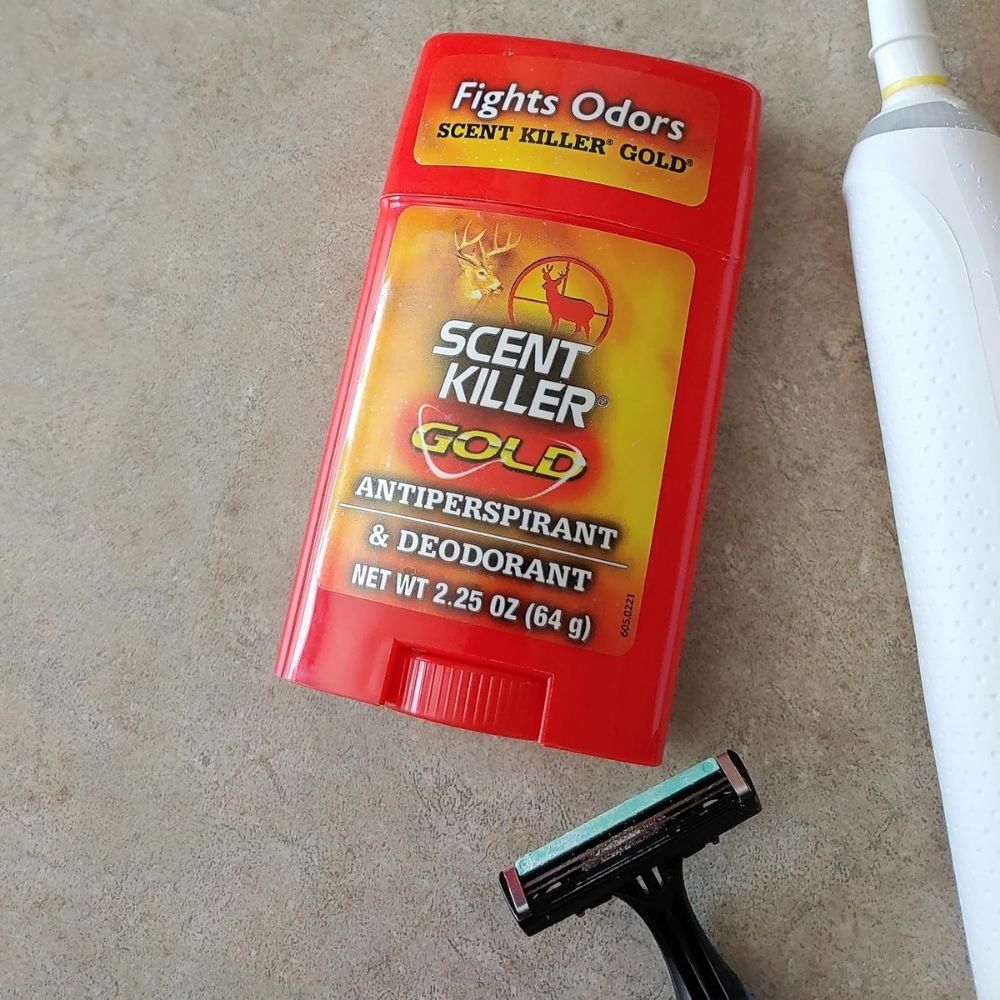 Scent Killer Gold antiperspirant and deodorant stick displayed with a razor and toothbrush on a countertop
