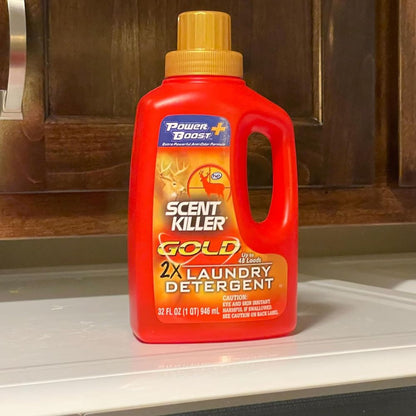 Red bottle of Scent Killer Gold 2X Laundry Detergent on a kitchen counter.