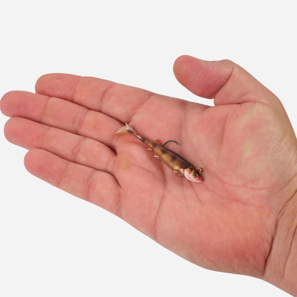 Hand holding a small fishing lure against a white background