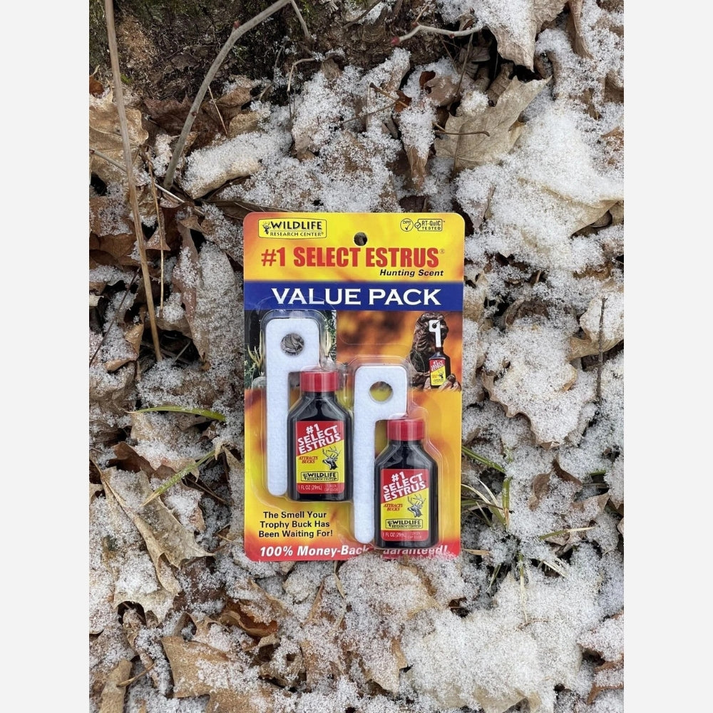 Packaged hunting scent product on a snowy ground