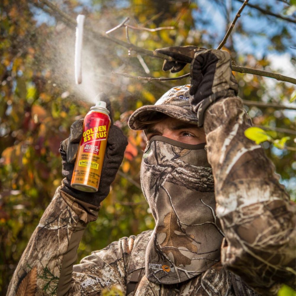 Person in camouflage gear holding a can of Goldenseal Plus outdoors