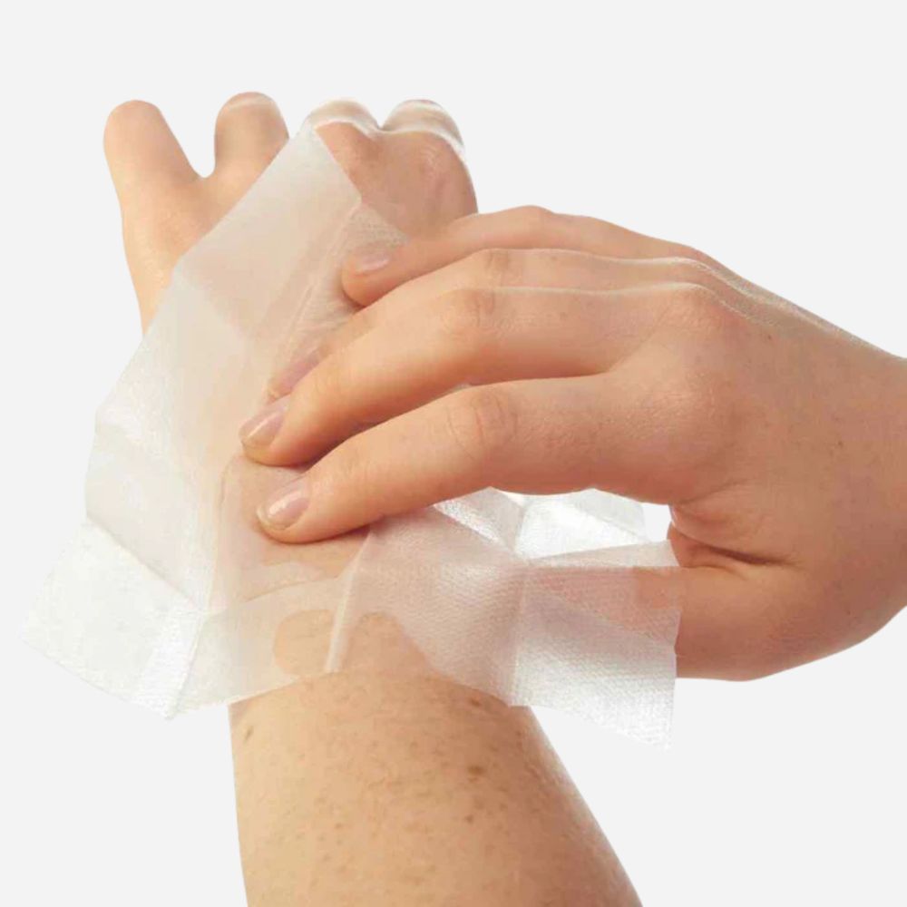 Hand applying a bandage to another hand on a white background