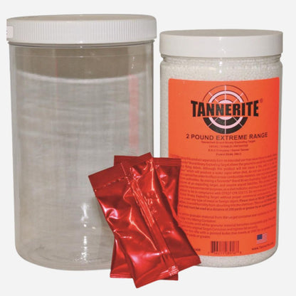 A clear plastic canister with a white lid, a white plastic jar labeled TANNERITE 2 POUND EXTREME RANGE, and three shiny red packets in front, shown on a plain white background.
