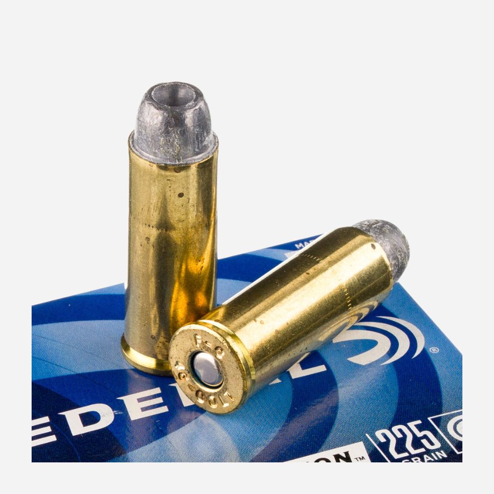 Two brass rifle cartridges on a blue Federal ammunition box.