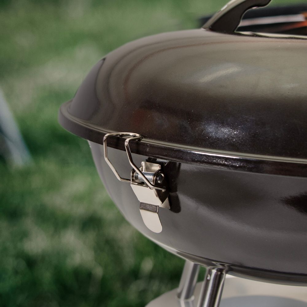 Close-up of a black barbecue grill with a blurred green background