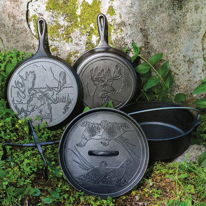 Three cast iron skillets with engraved designs on a natural background