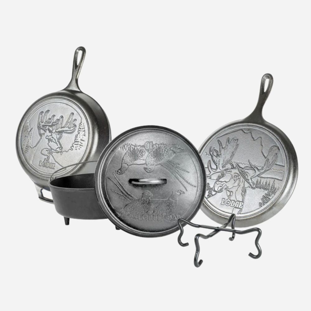 Set of three metal skillets with engraved designs on a white background