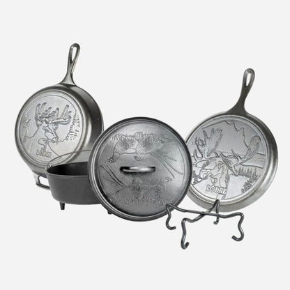 Set of three metal skillets with engraved designs on a white background