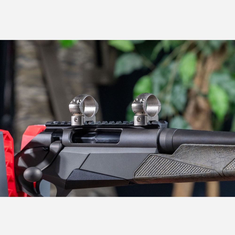 Close-up of a rifle with scope rings on a natural background