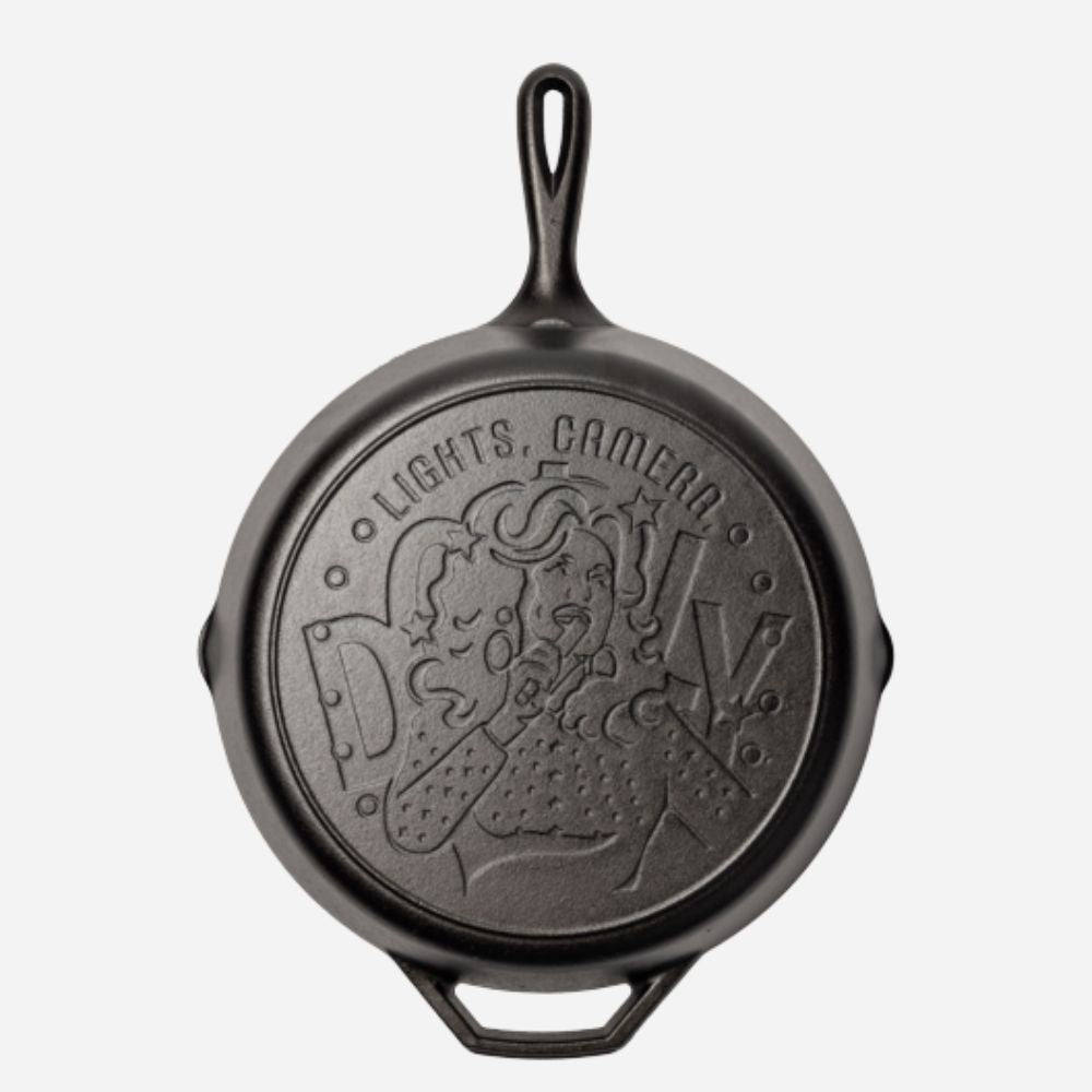 Black cast iron skillet with embossed design on a white background