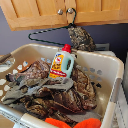 Laundry basket with clothes and a bottle of detergent on a kitchen counter.