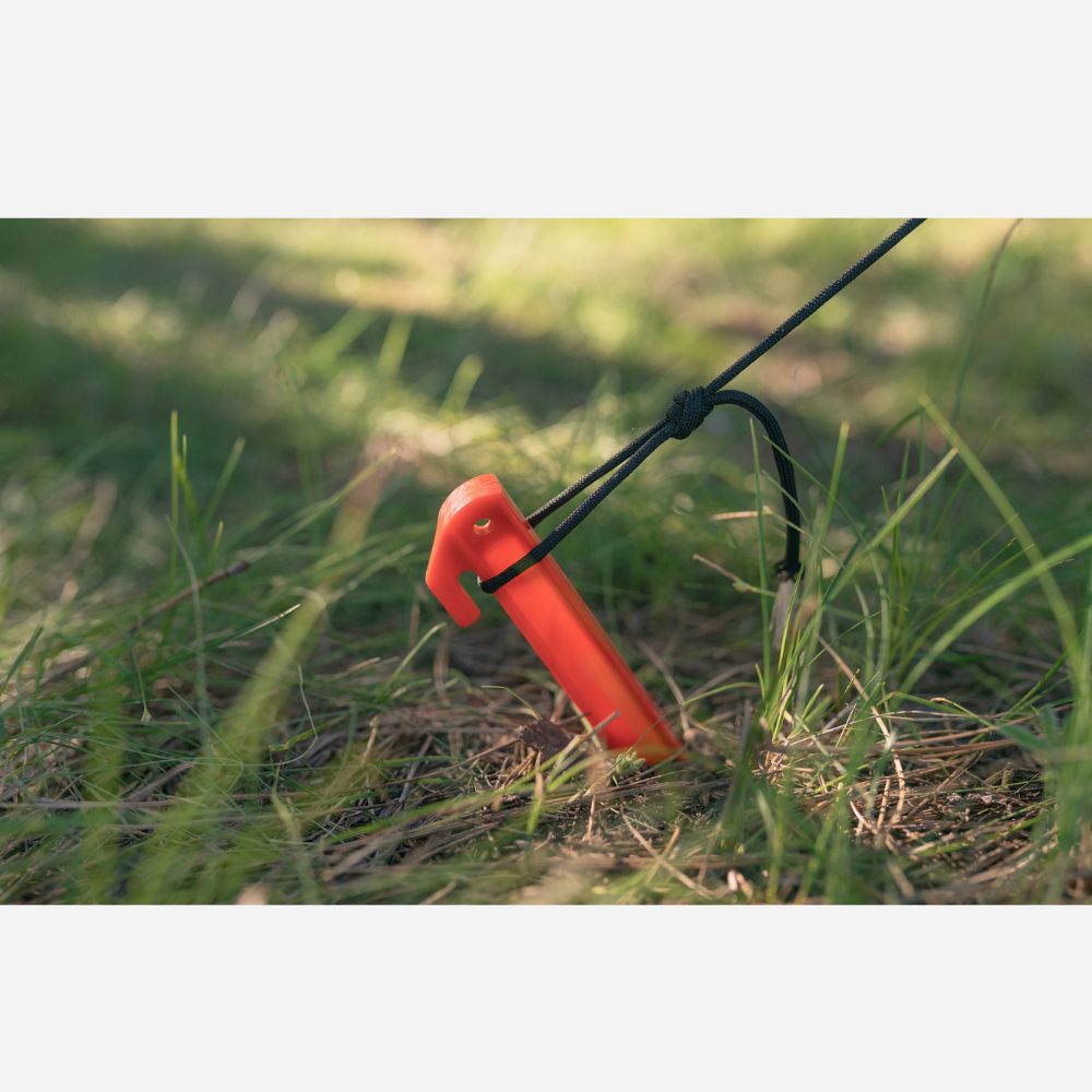 Red metal detector head on grass with a blurred background