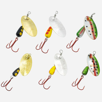 Six fishing spinners arranged in two rows on a light gray background. The lures include metallic gold, silver, yellow, black, red, and green color combinations with treble hooks.
