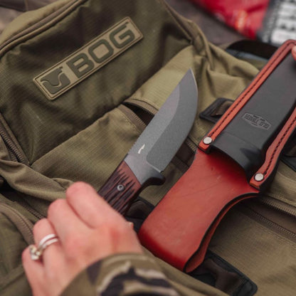 Knife with red sheath on a green bag with 'BOG' branding