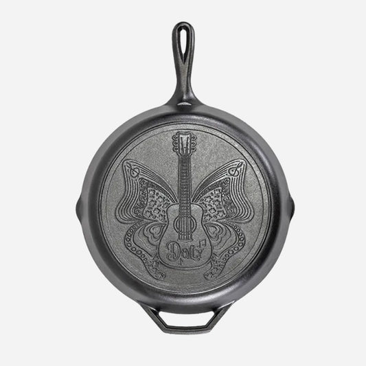 Black cast iron skillet with guitar and butterfly design on a white background