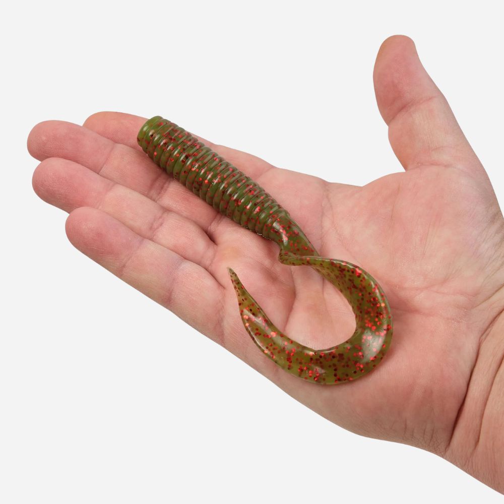 Hand holding a green and red fishing lure against a white background