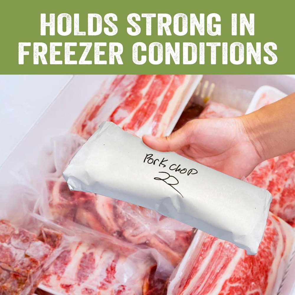Hand holding a labeled freezer bag with text 'Holds Strong in Freezer Conditions' over a background of frozen meat.