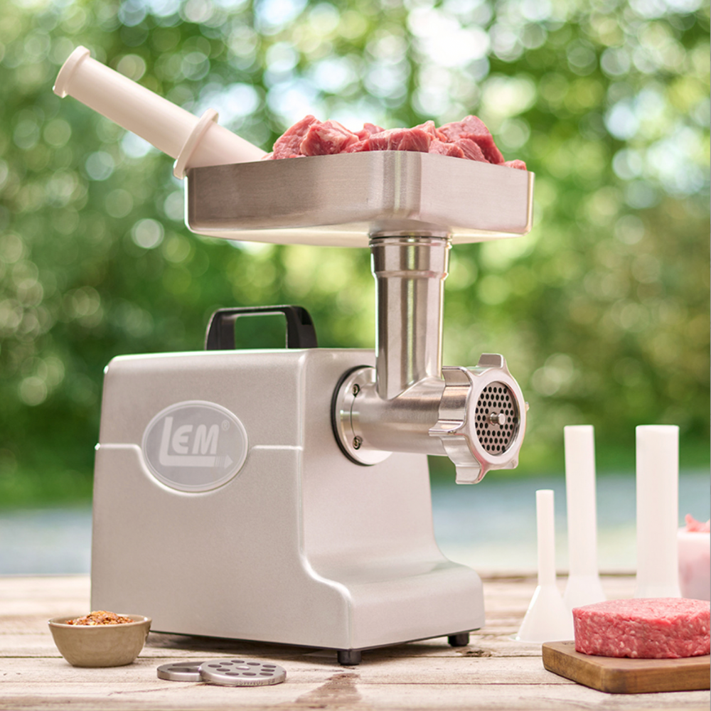 LEM meat grinder with ground meat on a wooden surface outdoors