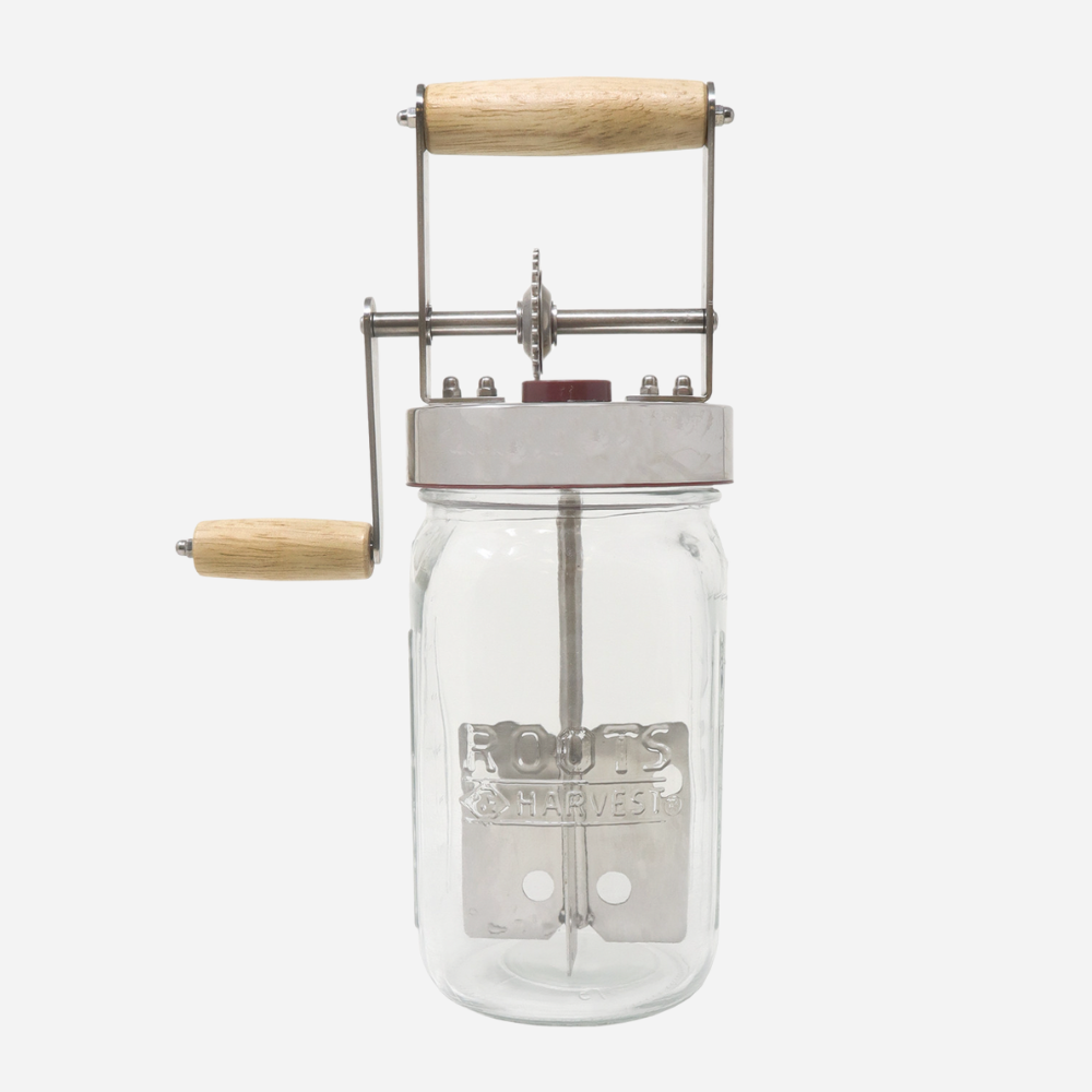 Clear glass jar with metal press and wooden handles on a white background