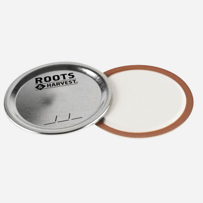 Metallic lid with a white interior and brown rim on a white background, featuring the 'Roots Harvest' brand.
