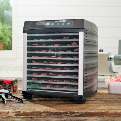 Dehydrator with trays of food on a wooden surface