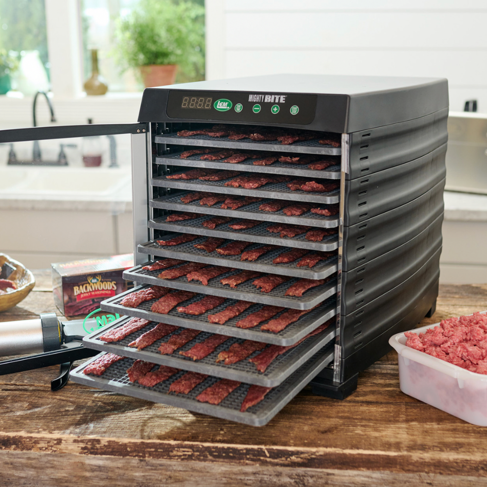 Food dehydrator with trays of food on a wooden table