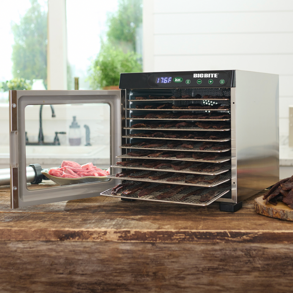 Big Bite dehydrator with open door on a wooden surface, displaying various food items.