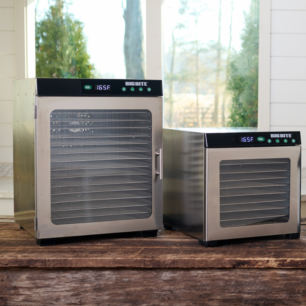 Two silver dehumidifiers on a wooden surface with a window in the background