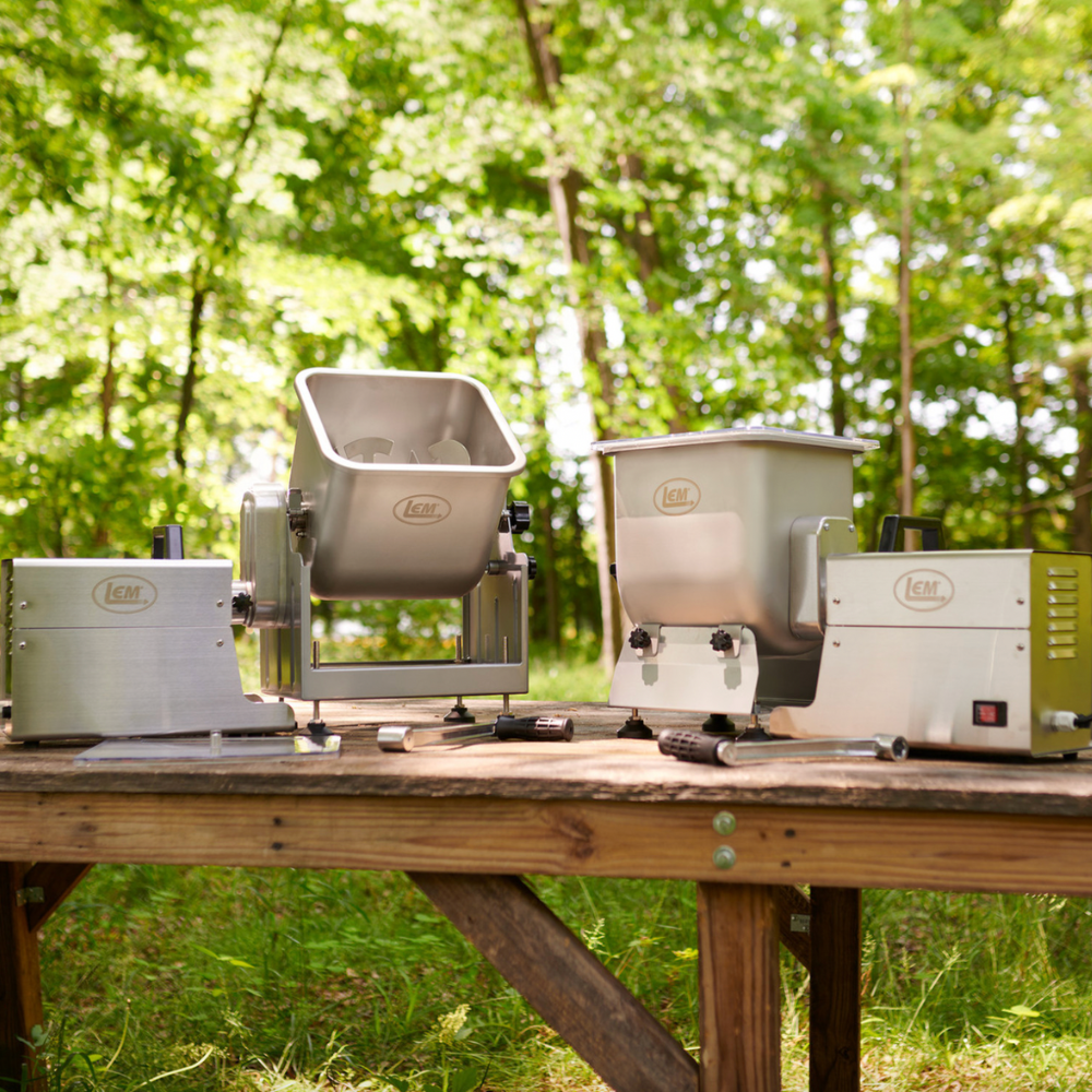 Outdoor setting with camping gear on a wooden table against a forest background