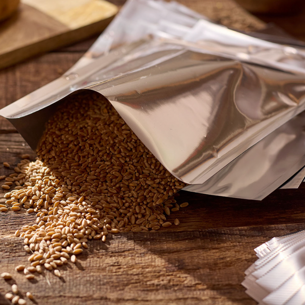 Aluminum foil packet with spilled seeds on a wooden surface
