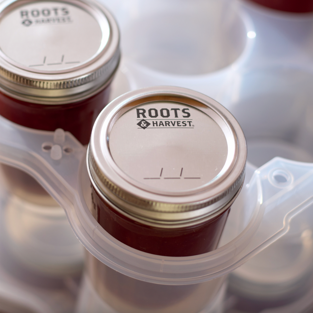 Jars with 'ROOTS HARVEST' lids in a container